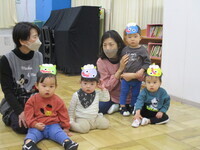 0歳児がお面をつけている様子の写真