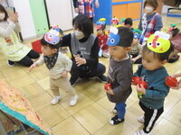 鬼ボードめがけてボールを投げている0歳児の写真