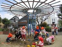 砂場で遊んでいる乳児クラスの様子の写真