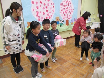 乳児クラスからプレゼントをもらう様子の写真