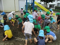 どろんこ遊びをしている4,5歳児の写真