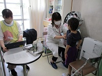 お腹を診察してもらっている子どもの様子の写真