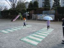写真：傘をさして横断歩道を渡る練習