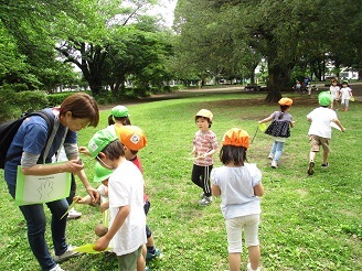 4歳児と5歳児が自然物のスタンプラリーをしている写真