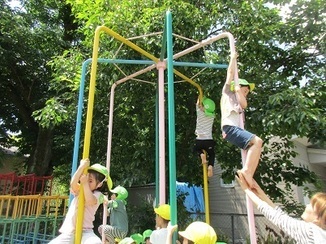 幼稚園の登り棒で保育園の子ども達が遊んでいる写真