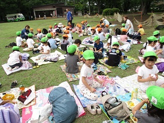子ども達が遠足でお弁当を食べている写真