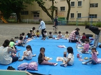 園庭でお弁当を食べている写真