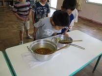 完成したカレーの香りをかぐ写真