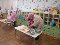 5歳児が包丁で野菜を切っている写真です。