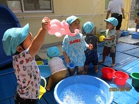 1歳児の子が、水浴びをしているの様子の写真