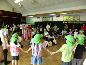 幼稚園の夏祭りで盆踊りをしている様子の写真
