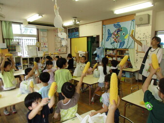 とうもろこしをむき終わってポーズをとっている様子の写真