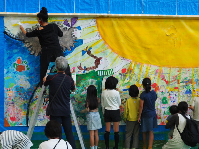 蟹江杏さんと子どもたちが絵を描いている様子の写真