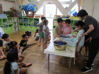 写真:鍋に入れてTシャツを染めている様子をみんなで見ているところ