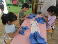 写真:染めたTシャツの輪ゴムを取っているところ