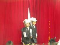 幕の前に3歳児がいる写真