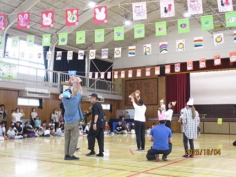0歳児クラスがお父さん、お母さんに抱っこされ踊っている様子の写真