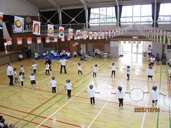 4歳児の子どもがフラフープをもって踊っている様子の写真