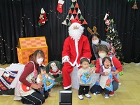0歳児クラスの子供達とサンタクロースの写真
