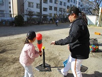 バットでボールを打っている様子の写真