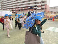 傘をさして歩く写真