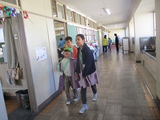 5歳児らいおん組が旭が丘小学校の5年生に学校を案内してもらっている様子の写真