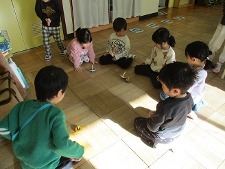 4歳児ぱんだ組がコマであそんでいる様子の写真