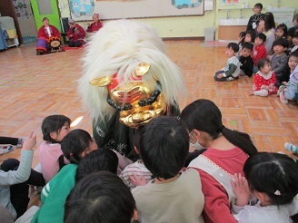 誕生会で獅子に頭を食べてもらっている様子の写真