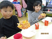 出来上がったピザを見て、喜んでいる子どもの写真