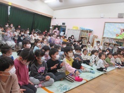 観劇会で絵本のスライドショーを見る子どもの画像