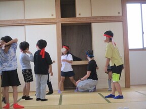 写真：子どもたちと学生ボランティアさんが隠れる場所を考えています。
