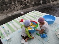 写真:4歳児がたらいで水あそびをしている様子
