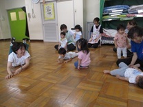 先生と寝転がる子供の写真