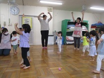 カラカラを持って、バンザイをする子供の写真