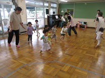 ピアノに合わせてホールを走る2歳児の写真