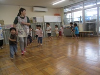 ピアノに合わせてホールを歩く3歳児の写真